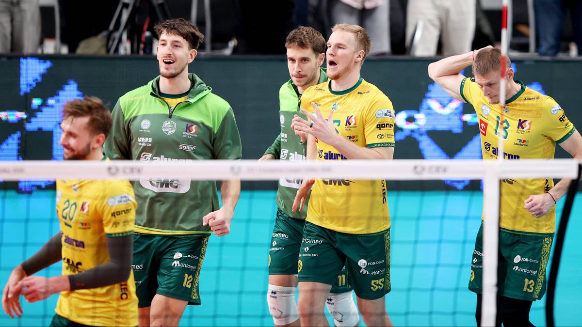 Siatkarze w ż&oacute;łtych i zielonych strojach rywalizują przy siatce.