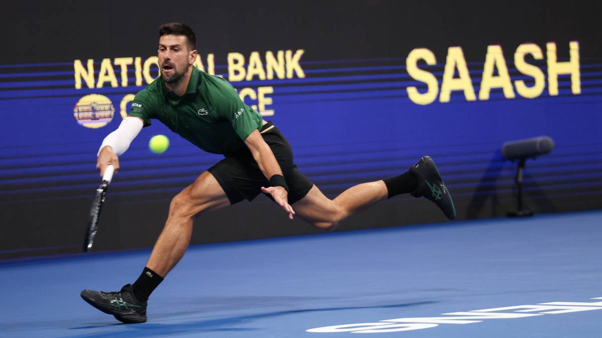 Novak Djoković podczas meczu tenisowego, wykonuje uderzenie forhendowe.