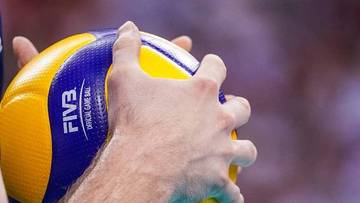 Dłoń trzymająca piłkę do siatk&oacute;wki z napisem FIVB Official Game Ball